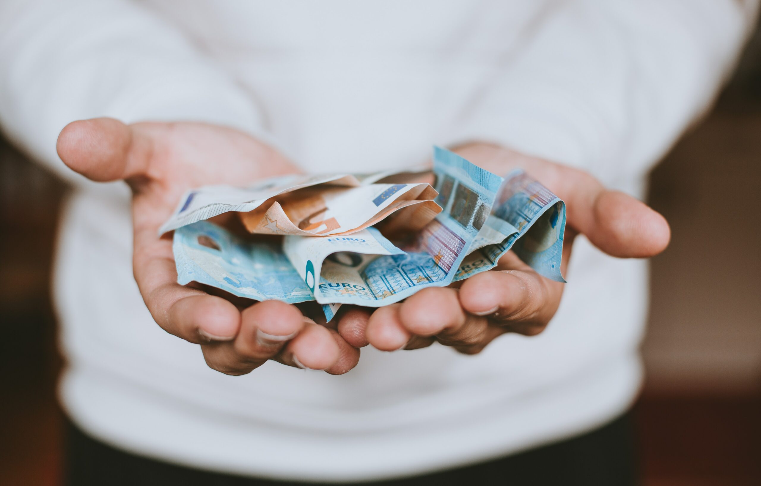 Zwei Hände halten Euro Geldscheine